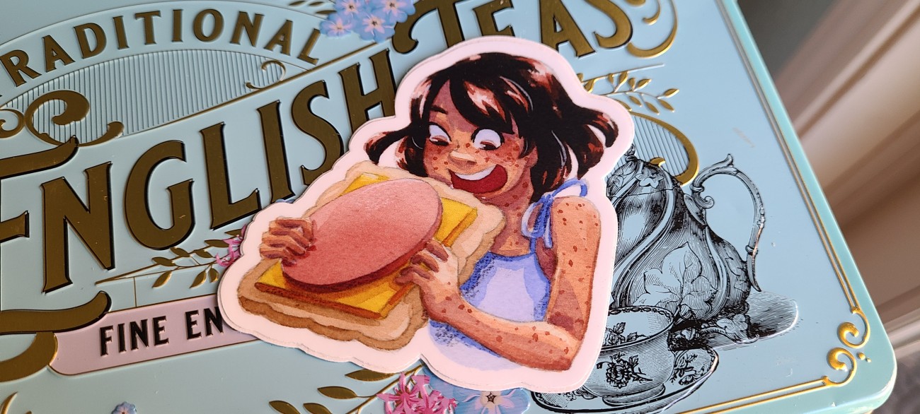 A vinyl sticker of Kara chowing down on a Lunchable.  She is very excited about this little sandwich.